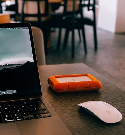 MacBook, souris et disque dur externe sur un bureau