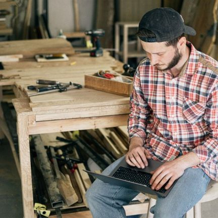 Artisan travaillant sur son ordinateur portable dans son atelier