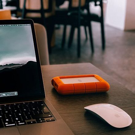 MacBook, souris et disque dur externe sur un bureau