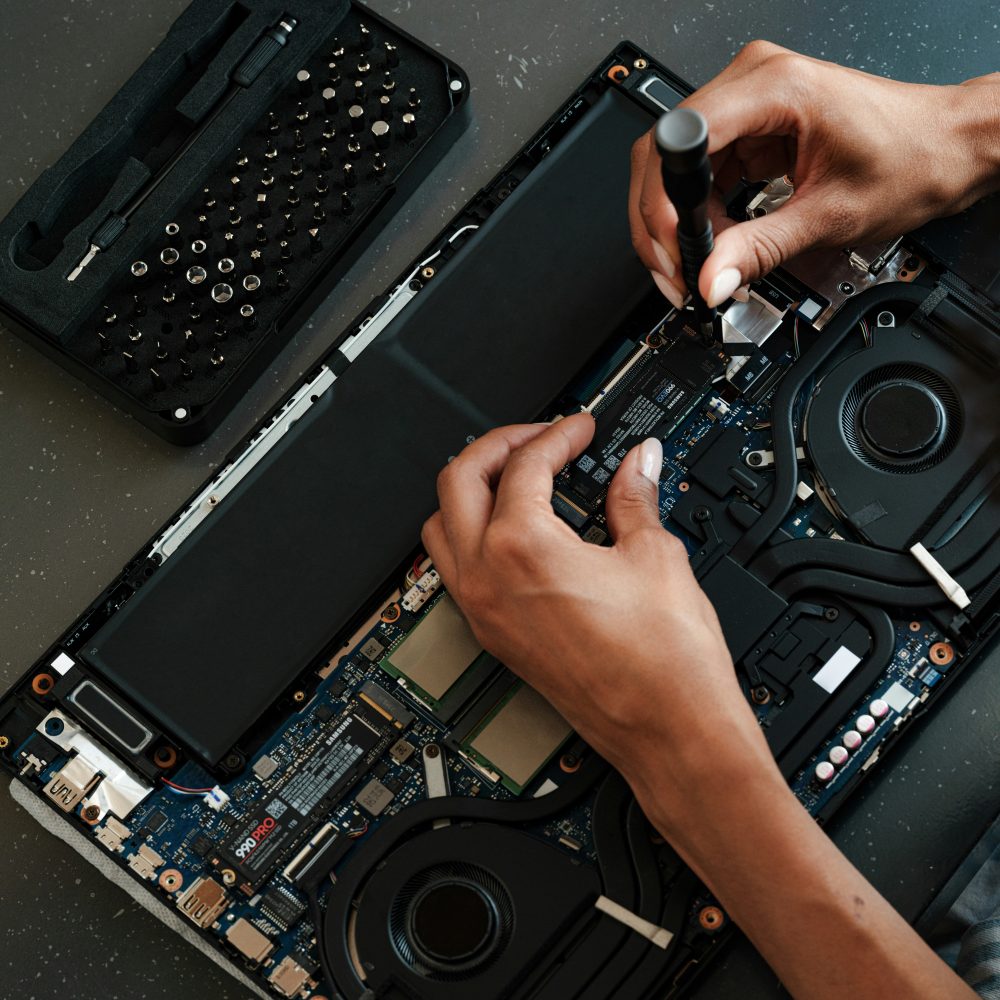 Mains qui remplacent un disque SSD dans un ordinateur portable ouvert